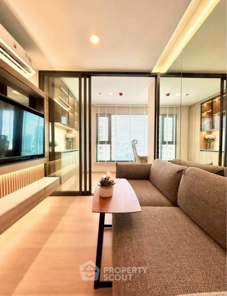 Modern living room with sleek design and large windows offering city views.