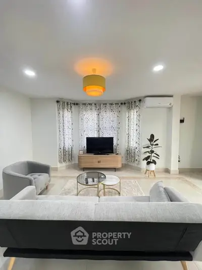 Modern living room with stylish furniture and natural light, featuring a cozy seating area and contemporary decor.