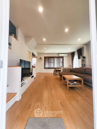 Spacious modern living room with wooden flooring and cozy seating area.