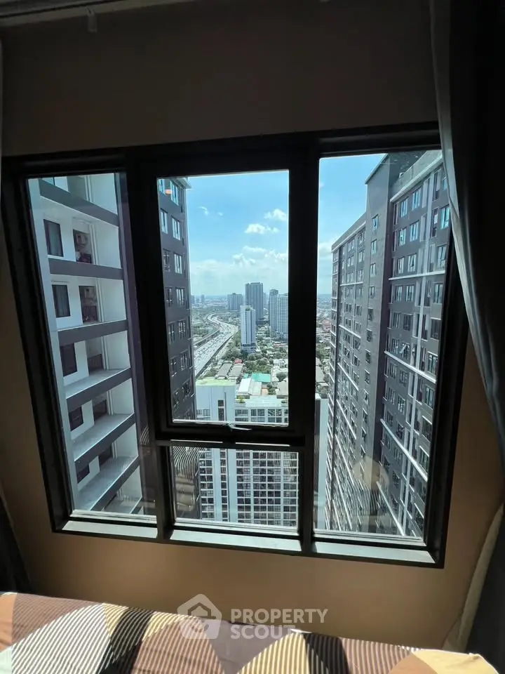 Stunning high-rise city view from a modern apartment window, showcasing urban living at its finest.