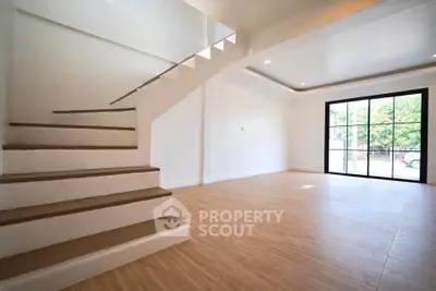 Spacious modern living room with staircase and large windows