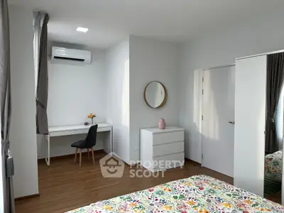 Modern bedroom with stylish decor, featuring a desk, mirror, and air conditioning for comfort.