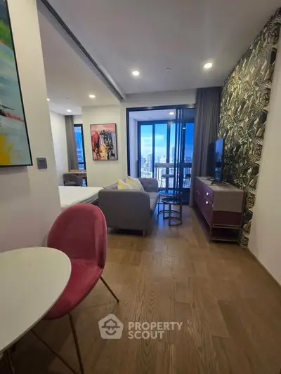 Stylish modern living room with balcony view in a chic apartment, featuring contemporary decor and vibrant artwork.