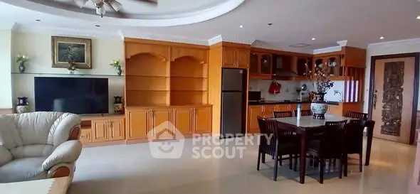 Spacious open-plan living room with elegant wooden cabinetry and modern kitchen.