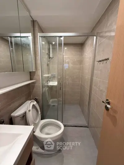 Modern bathroom with glass shower and sleek fixtures in a contemporary apartment.