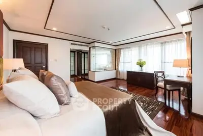 Luxurious bedroom with elegant decor and large windows offering natural light.