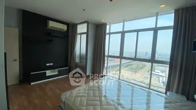 Spacious bedroom with large windows offering stunning city views.