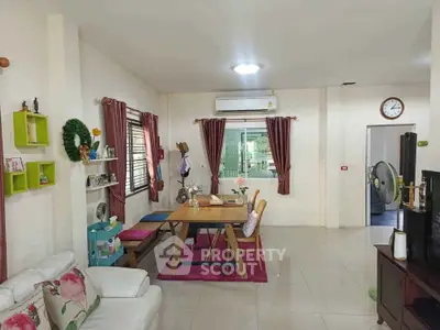 Charming living room with dining area, featuring cozy decor and natural light, perfect for family gatherings.