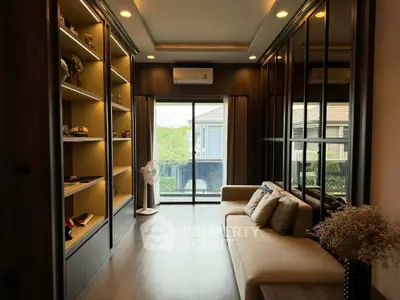Stylish living room with modern decor and large windows offering natural light and garden view.