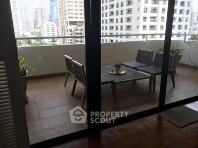 Spacious balcony with modern furniture and city view, perfect for relaxation.