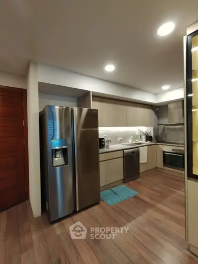 Modern kitchen with stainless steel appliances and wooden flooring