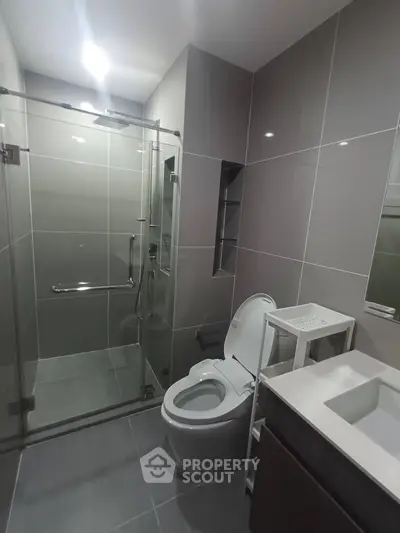 Modern bathroom with sleek design, glass shower enclosure, and elegant fixtures.