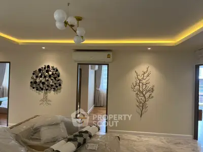 Modern living room with stylish decor and ambient lighting, featuring elegant wall art and contemporary furnishings.