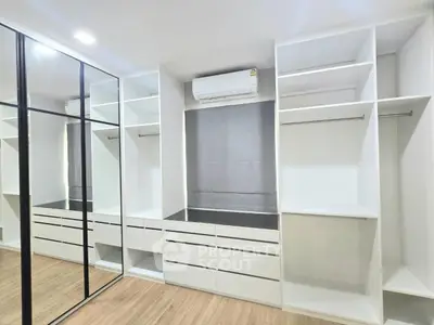 Spacious walk-in closet with mirrored sliding doors and ample storage space.