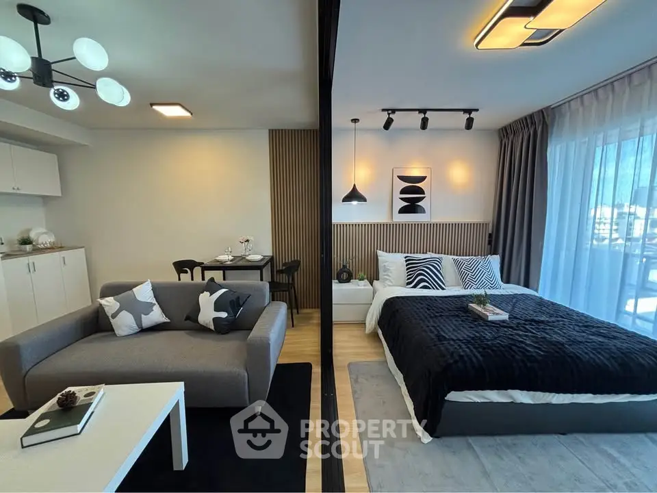 Modern open-plan living room and bedroom with stylish decor and natural light.