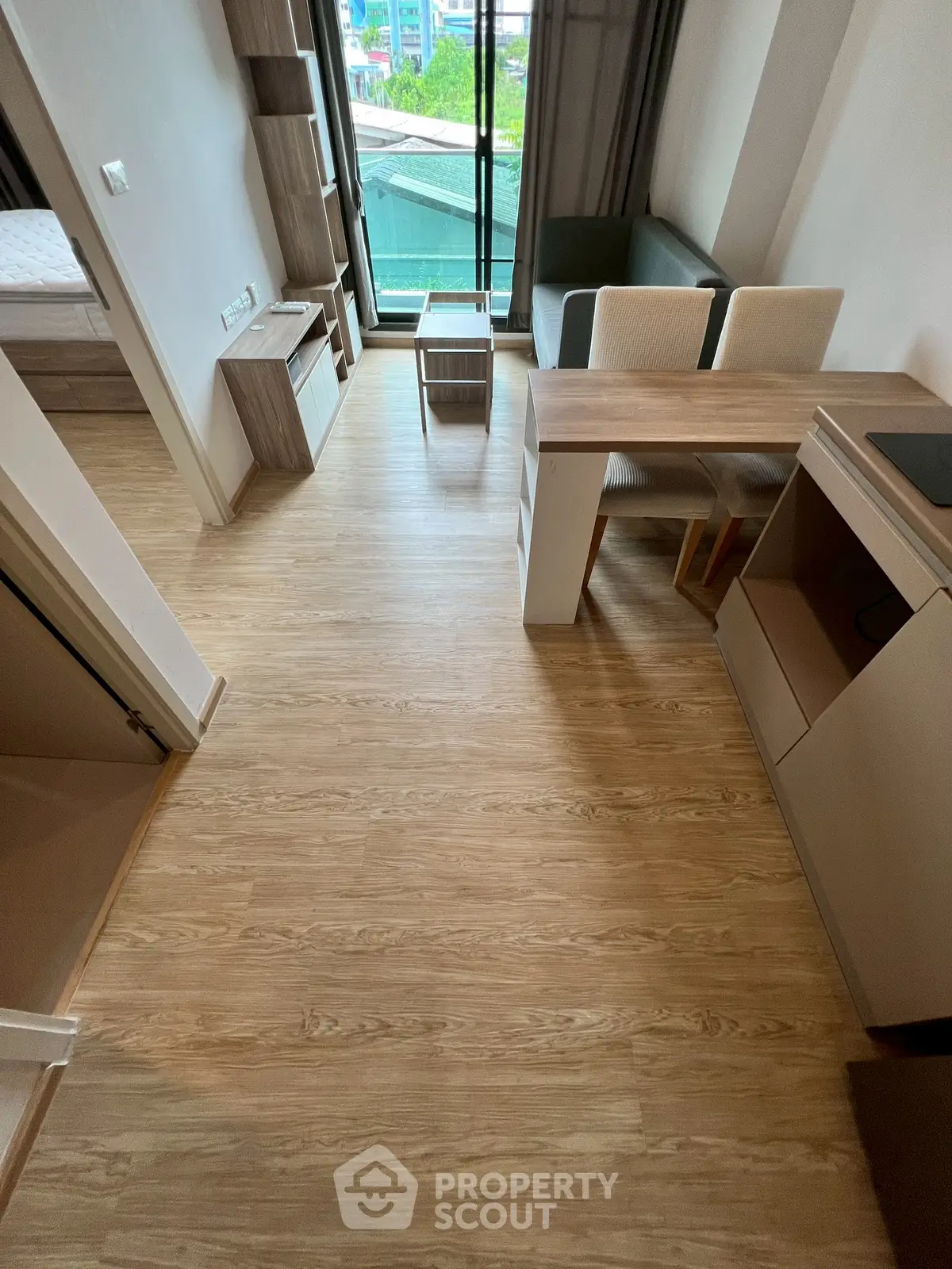 Modern studio apartment with wooden flooring and compact kitchen area.