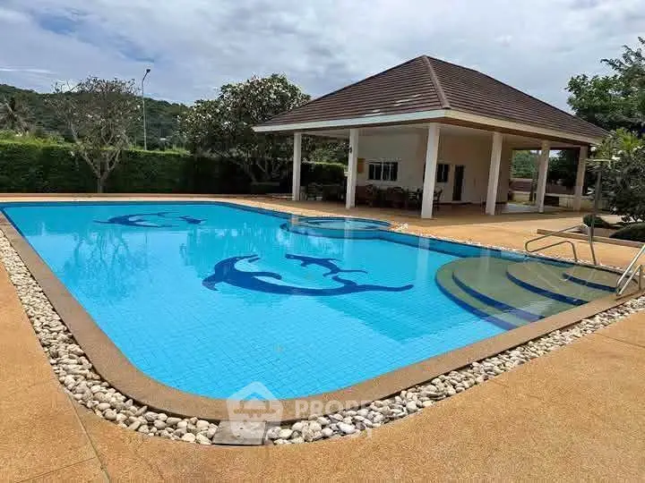 Luxurious outdoor pool with dolphin design in serene garden setting
