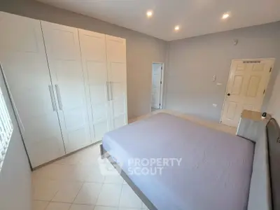 Spacious bedroom with modern wardrobe and cozy bed in a bright setting.