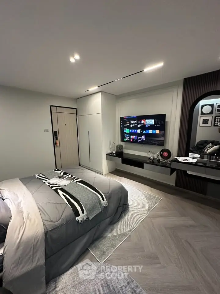 Modern bedroom with sleek design, featuring a wall-mounted TV and stylish decor.