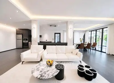 Luxurious open-plan living room with modern furniture and elegant decor, featuring a spacious layout and natural light.