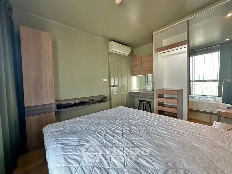 Modern bedroom with stylish furniture and natural light, featuring a comfortable bed and built-in wardrobe.