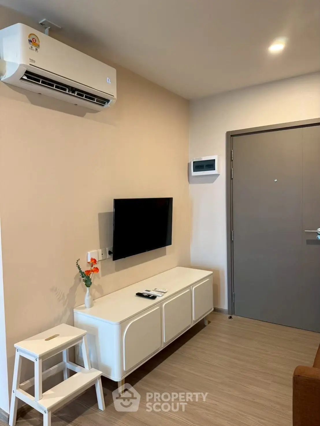Modern living room with air conditioning and sleek TV setup, perfect for comfortable living.
