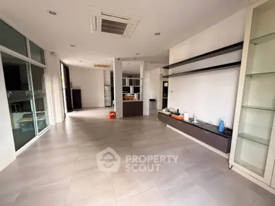 Spacious modern living room with sleek shelves and large windows, perfect for natural light and contemporary living.