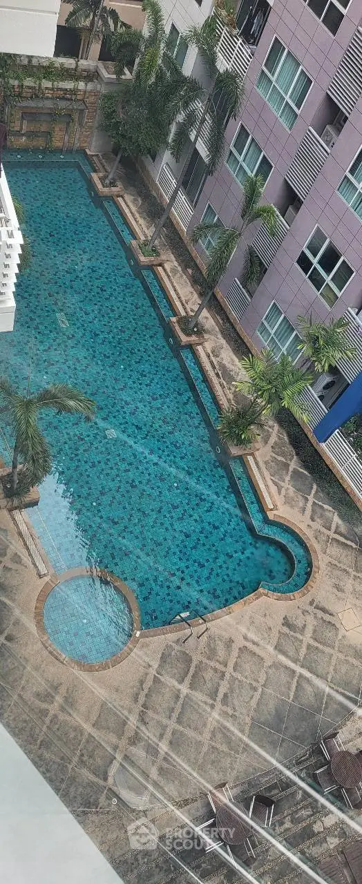 Luxurious apartment complex with a stunning outdoor pool and lush palm trees.