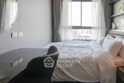 Modern bedroom with city view, featuring a cozy bed and stylish desk, perfect for urban living.