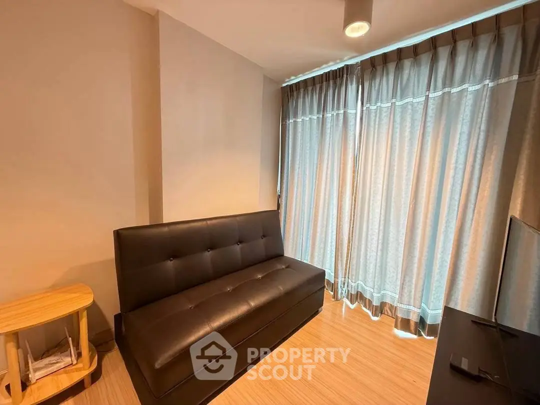 Cozy living room with modern sofa and floor-to-ceiling curtains, perfect for relaxation.