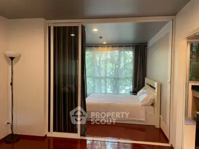 Cozy bedroom with large window and modern decor, perfect for relaxation.