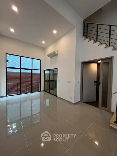 Spacious modern living room with high ceilings and large windows