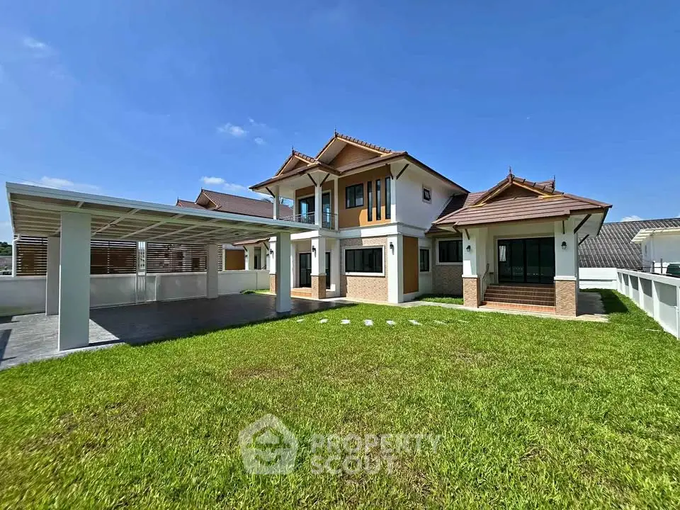 Stunning two-story house with spacious lawn and modern carport under clear blue sky.