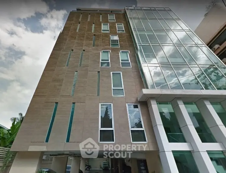 Modern commercial building with glass facade and parking area