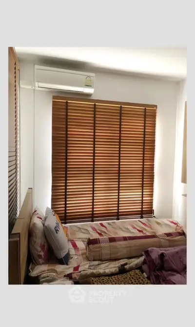 Cozy bedroom with air conditioning and stylish wooden blinds