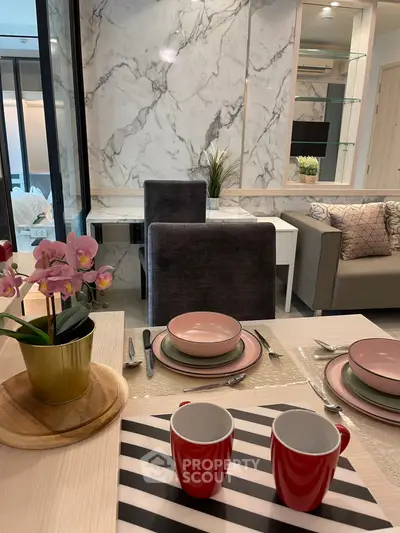 Modern dining area with elegant marble wall and stylish table setting in a cozy living space.