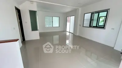 Spacious modern living room with glossy tiled floors and large windows for natural light.