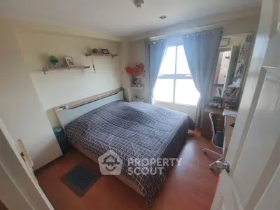 Cozy bedroom with large window and modern decor, perfect for relaxation and comfort.