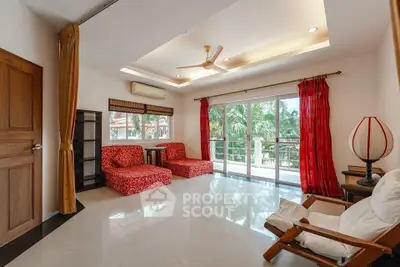 Spacious living room with modern decor and large windows overlooking lush greenery.