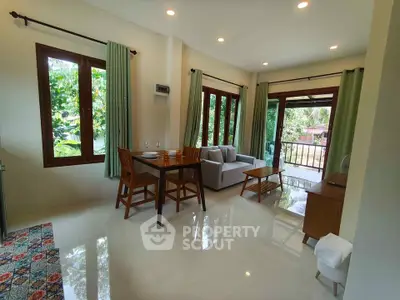 Charming living room with natural light and garden view, featuring cozy seating and elegant decor.
