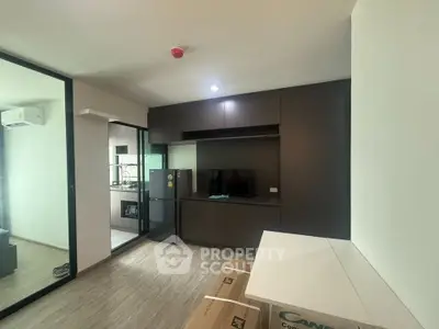 Modern living room with sleek cabinetry and open kitchen layout in a stylish apartment.
