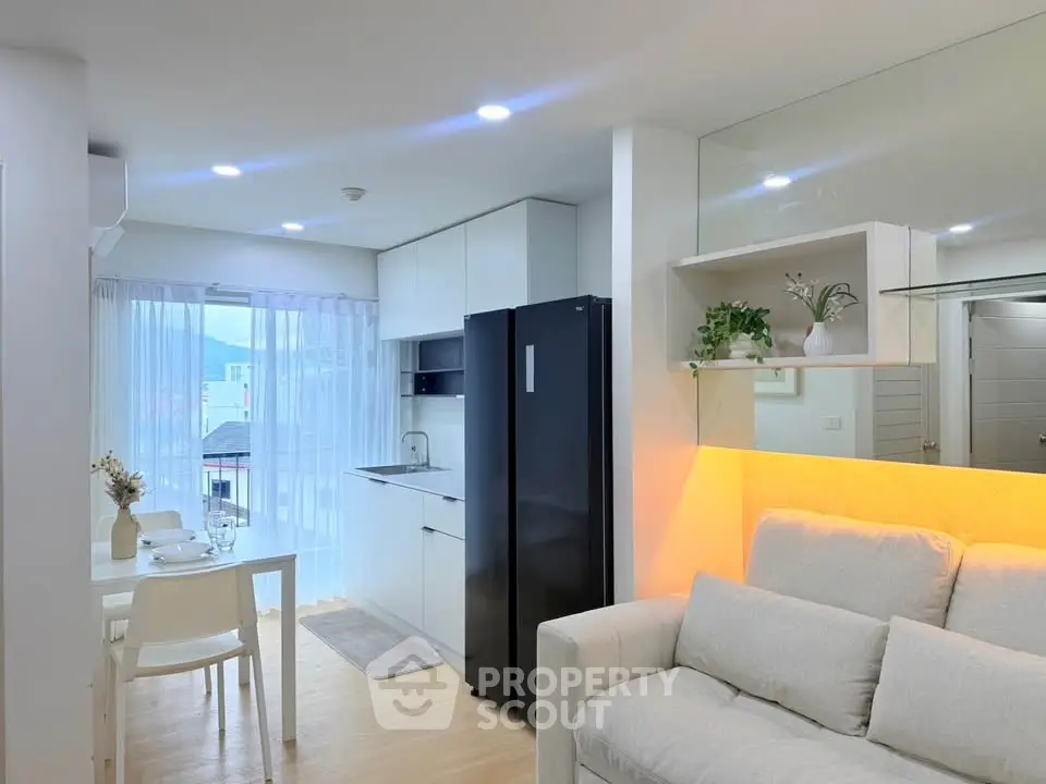 Modern open-plan living room and kitchen with sleek design and natural light.