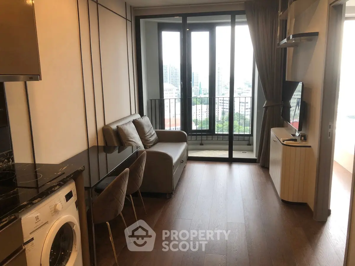 Modern living room with balcony view and washing machine in stylish apartment.