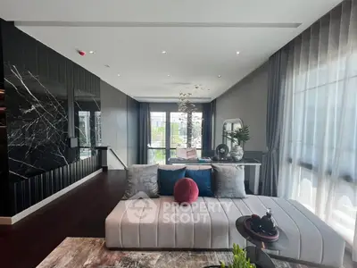 Luxurious modern living room with stylish decor and large windows offering natural light.