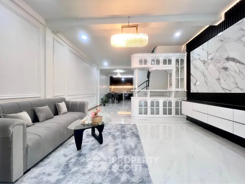Luxurious modern living room with elegant chandelier and marble accents