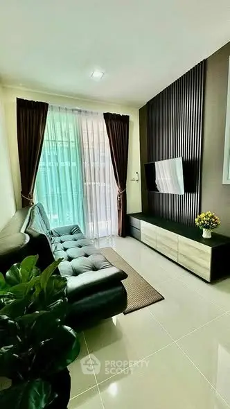 Modern living room with sleek furniture and large window, perfect for urban living.