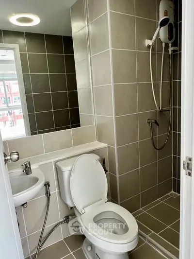 Modern bathroom with shower and toilet in sleek tiled design