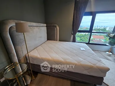 Spacious bedroom with large window offering stunning city views, featuring a luxurious bed and elegant decor.