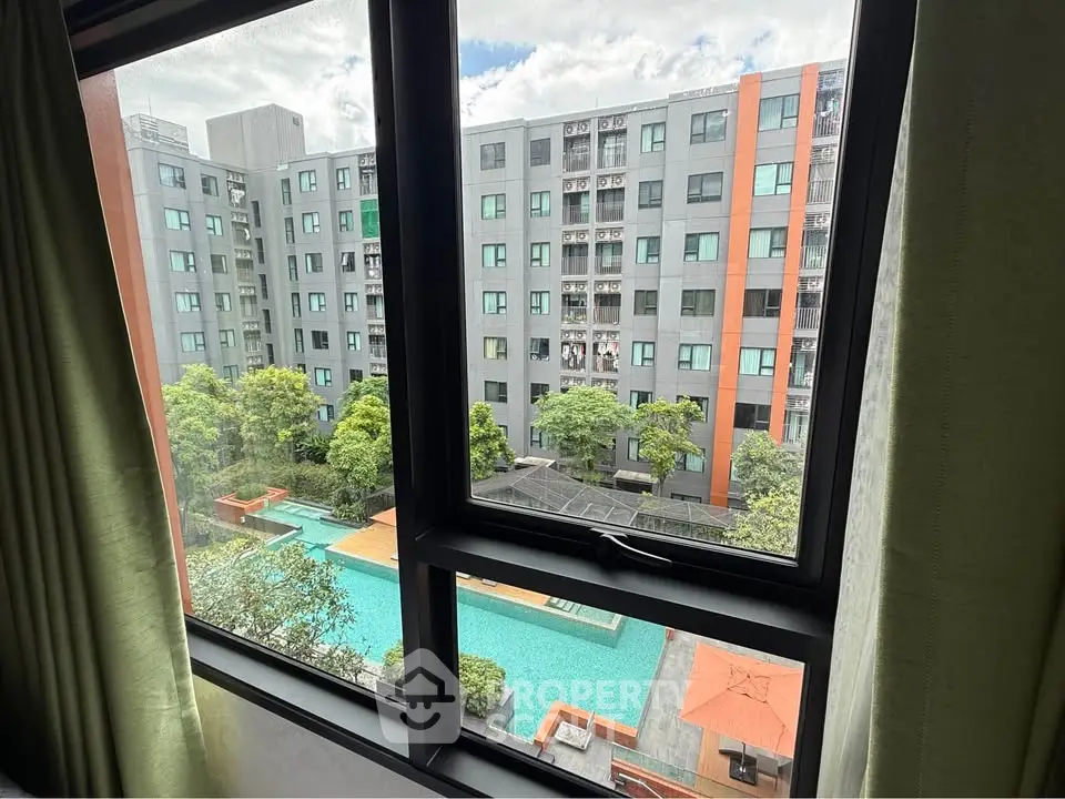 Modern apartment view with pool and lush greenery from window