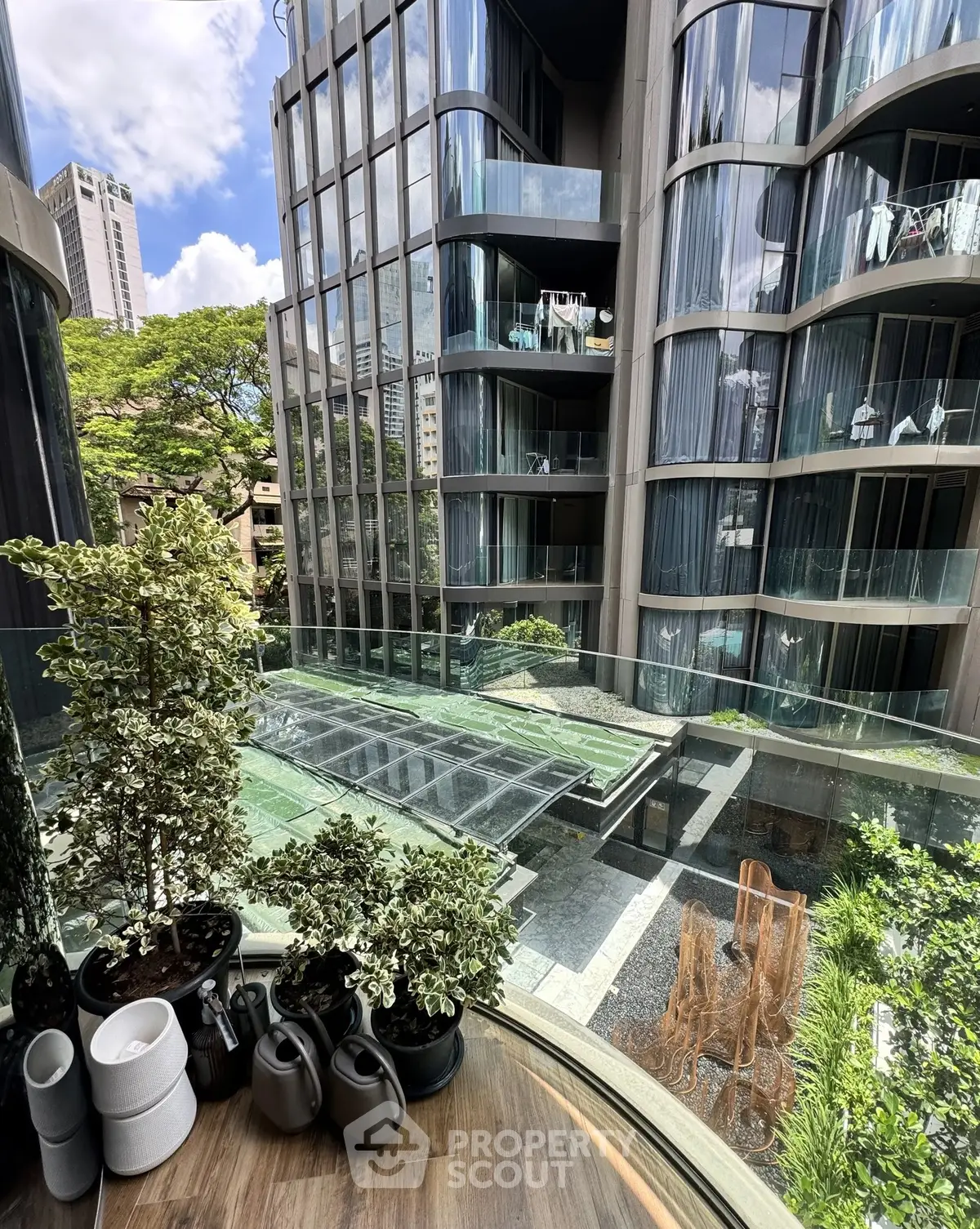 Luxurious modern building with glass balconies and lush greenery view